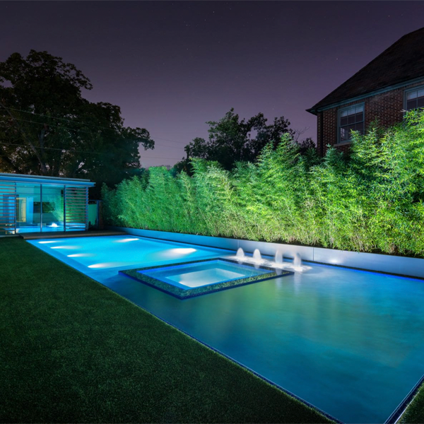 piscina desbordante con spa e iluminación nocturna