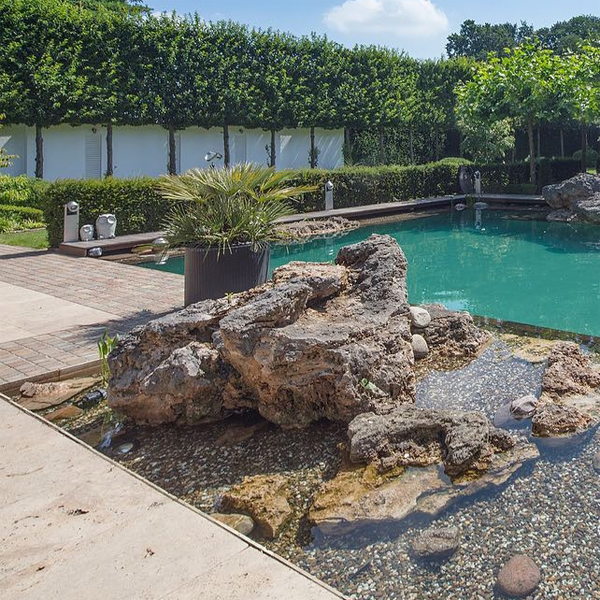 Piscina natural con grandes rocas, por Garten Terpelle