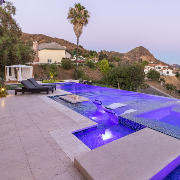 piscina infinity con spa integrado, al atardecer, en un proyecto en una colina de California, por Green Scene Landscaping