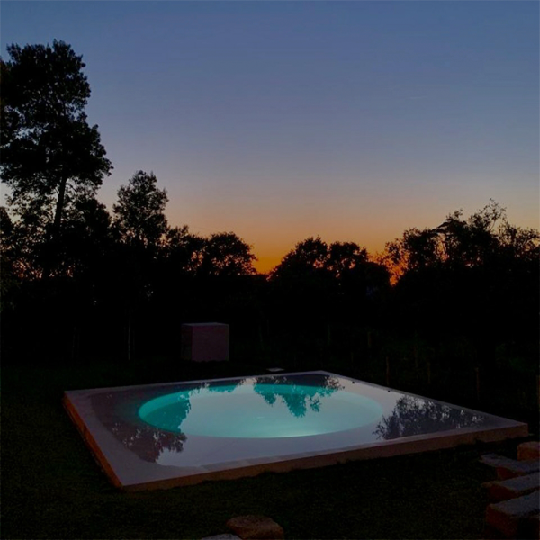piscina de diseño combinando líneas rectas y circulares at night