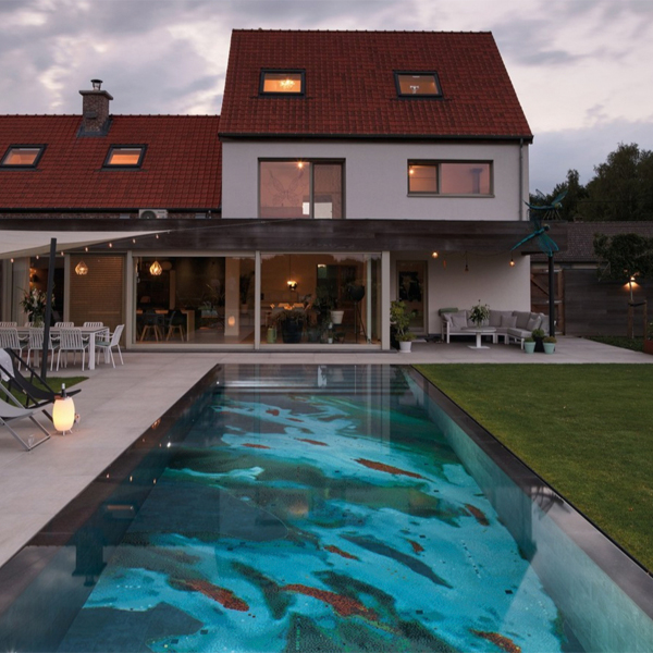 Piscina desbordante, estilo espejo, con un revestimiento único de dibujo abstracto, por H2eau Systems, por la noche.