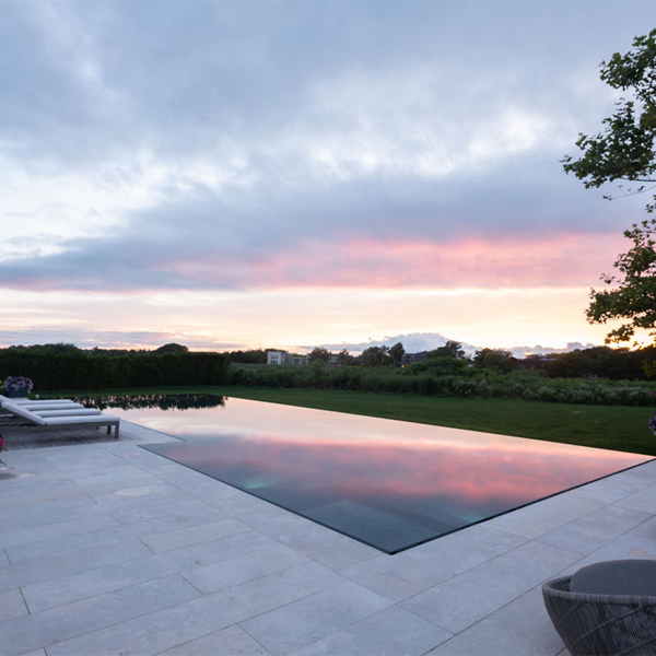 piscina desbordante tipo espejo al atardecer, en completo proyecto de paisajismo por Hollander Design