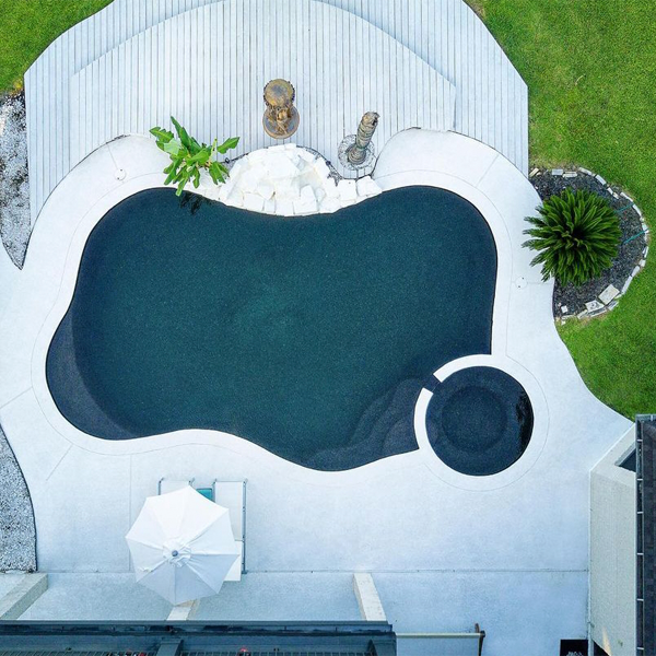 vista dron de piscina negra con spa, por J´s Pools and Spas