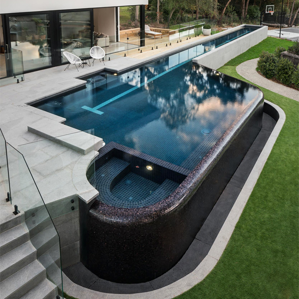 una piscina infinity de diseño único con spa incorporado, por Laguna Pools