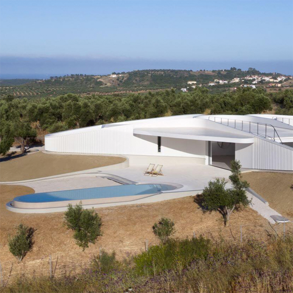 Vista dron de piscina infinita de diseño futurista y minimalista, en un moderno proyecto de casa de Lassa Architects