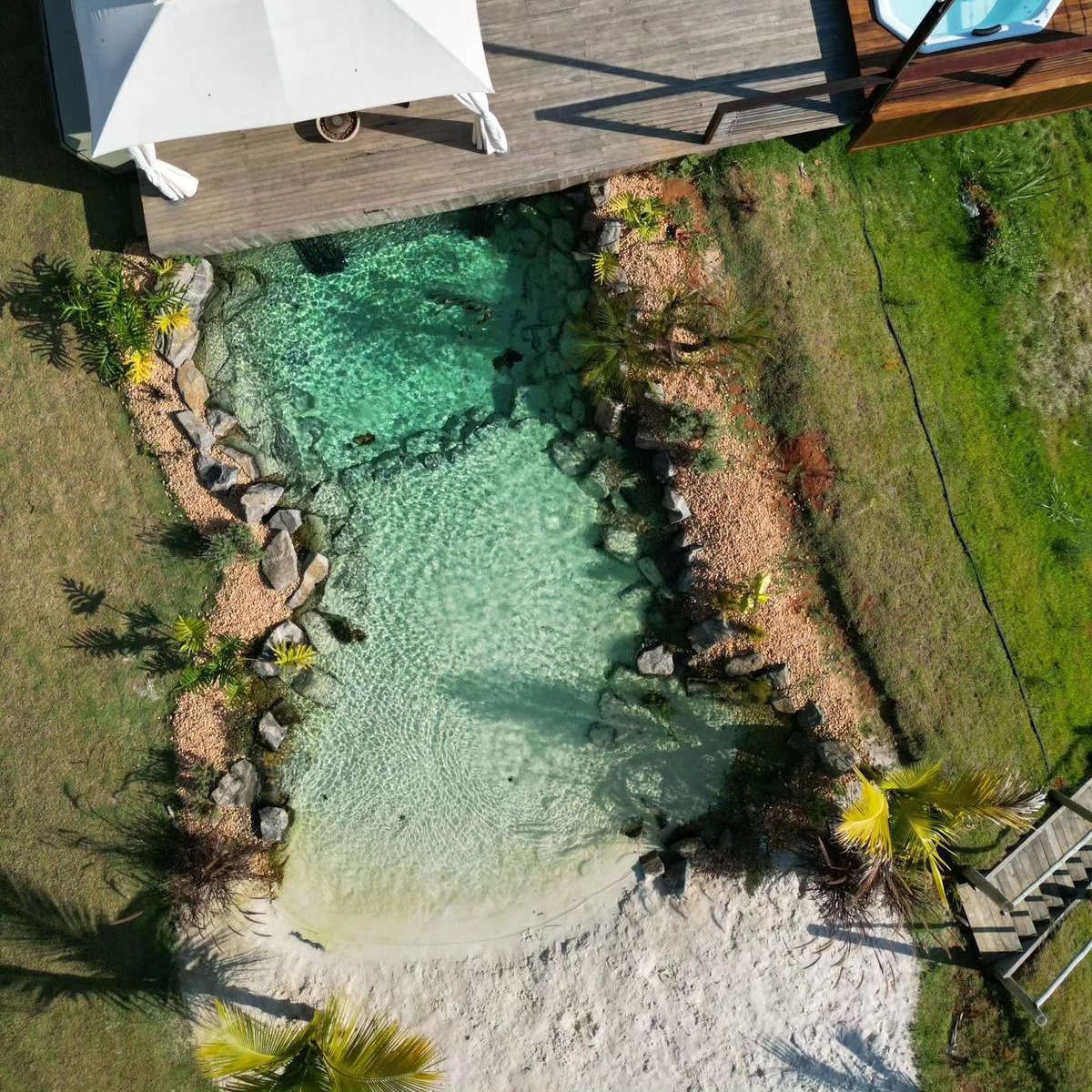 Vista dron de piscina biológica, estilo playa, por Life Ecossistemas, para Casa Grand Valley