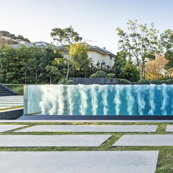 piscina infinity con pared transparente y spa incorporado, por Liquid Blue Pools