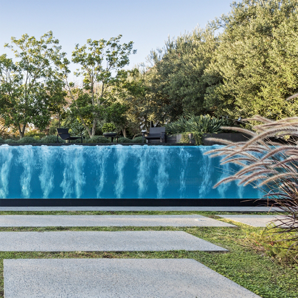 piscina infinity con pared transparente y spa incorporado, por Liquid Blue Pools
