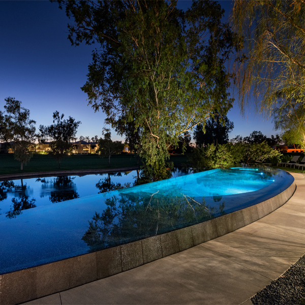 piscina infinity a medida con spa incorporado por la noche, de Liquid Evolution Pools