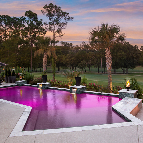 piscina geométrica a medida, iluminada con luces de colores, por Morehead Pools