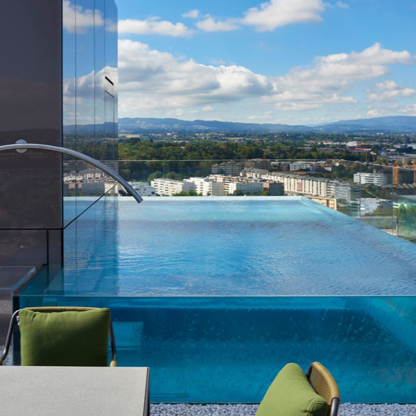 piscina infinity de acero con paredes transparentes, ubicada en un rooftop, realizada por Nicollier Group