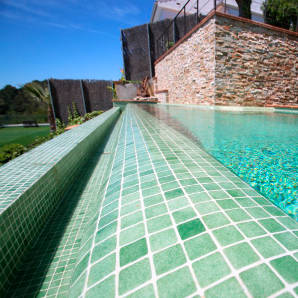 detalle gresite verde en piscina desbordante