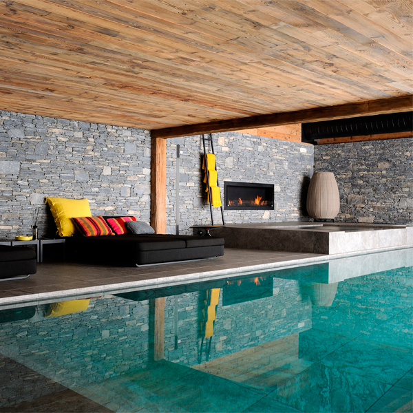 piscina infinity en interior con revestimiento porcelánicopor Piscines Concept