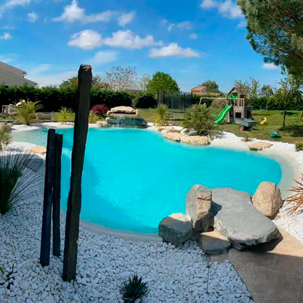 Piscina estilo laguna, con playa sumergida y paisajismo en un jardín de una casa particular, de HDP Pools