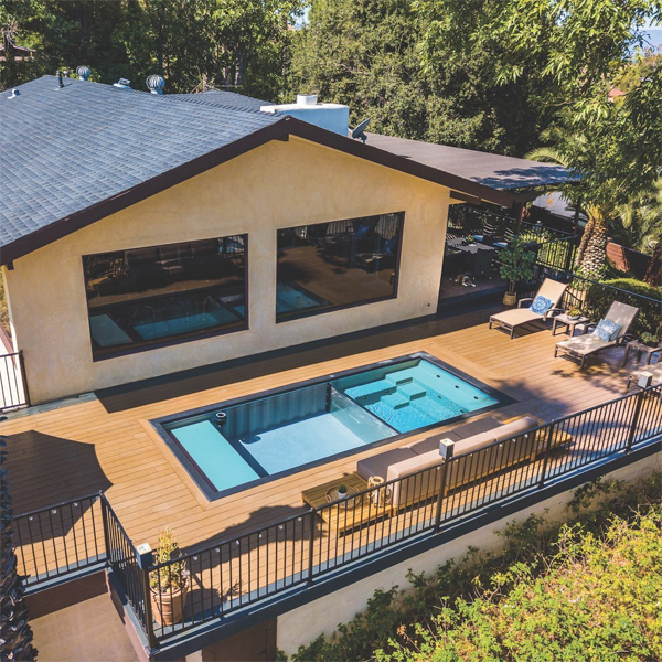 vista dron de mini piscina contenedor con espacio spa integrado, separado a través de una ventana subacuática transparente, por Precision Landscaping