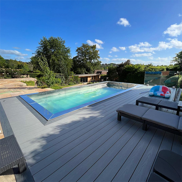 piscina de acero inoxidable, rodeada de tarima de madera sintética, en un proyecto de paisajismo de Raze Projects