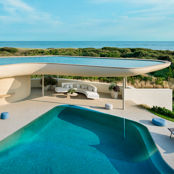 vista dron de una piscina desbordante, tipo espejo, dentro de un proyecto futurista y minimalista de Rees Roberts