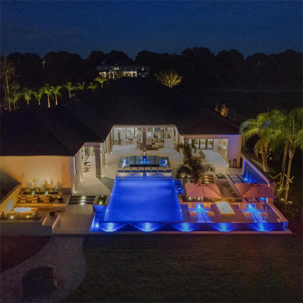 piscina espejo y spa iluminada por la noche por Ryan Hughes Design