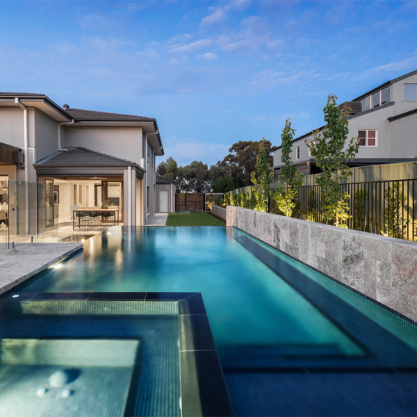 piscina infinity con spa por la noche de Simon Rosa Landscaping
