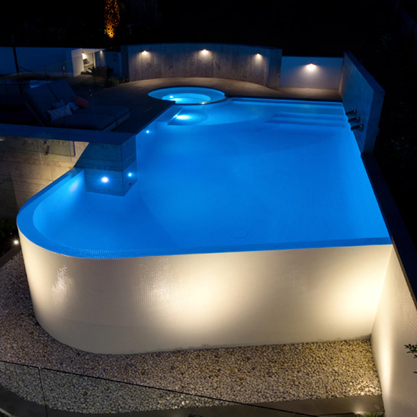 piscina infinity blanca a medida con spa por la noche