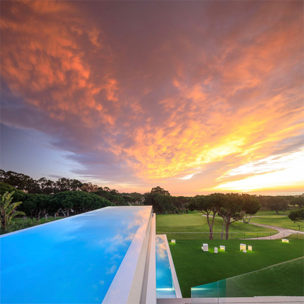 Un atardecer perfecto en una piscina infinita suspendidad, dentro de un proyecto de Vasco Vieira Arquitectos