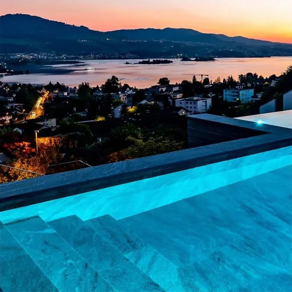 piscina infinita de lujo a medida, con espectaculares vistas sobre el lago al anochecer, por Vita Bad
