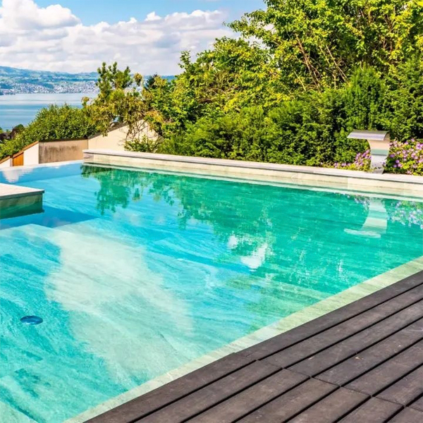 piscina infinita de lujo a medida, con cascada de acero inoxidable y espectaculares vistas sobre el lago, por Vita Bad