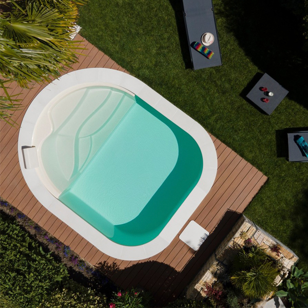 vista dron de mini piscina con formas redondeadas, rodeada de tarima de madera, por Waterair