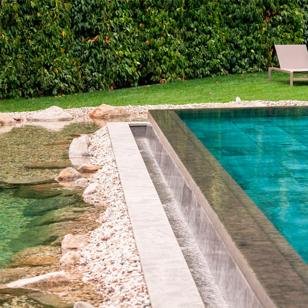 Espacio desbordante en una piscina de hotel rodeada de piedras y rocas, por Winkler Schwimmbad