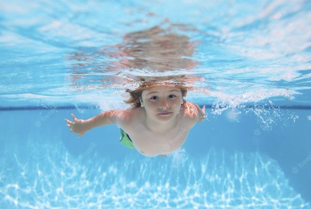 niño buceando en una piscina con cloración salina
