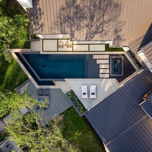 Vista dron de una piscina infinita con spa integrado y un diseño único, basado en líneas rectas y ángulos, por Pool Environments