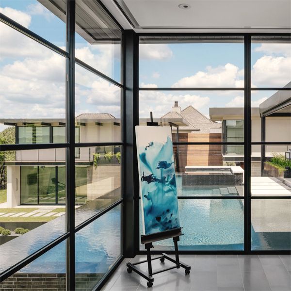 piscine à débordement et spa, par Aqua Builders, vu à travers les grandes fenêtres de la maison