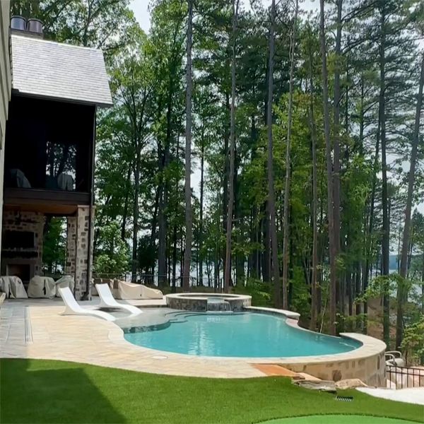 Piscine infinity sur mesure, avec spa intégré, par de Hot Springs Pools, dans un emplacement spectaculaire surplombant le lac
