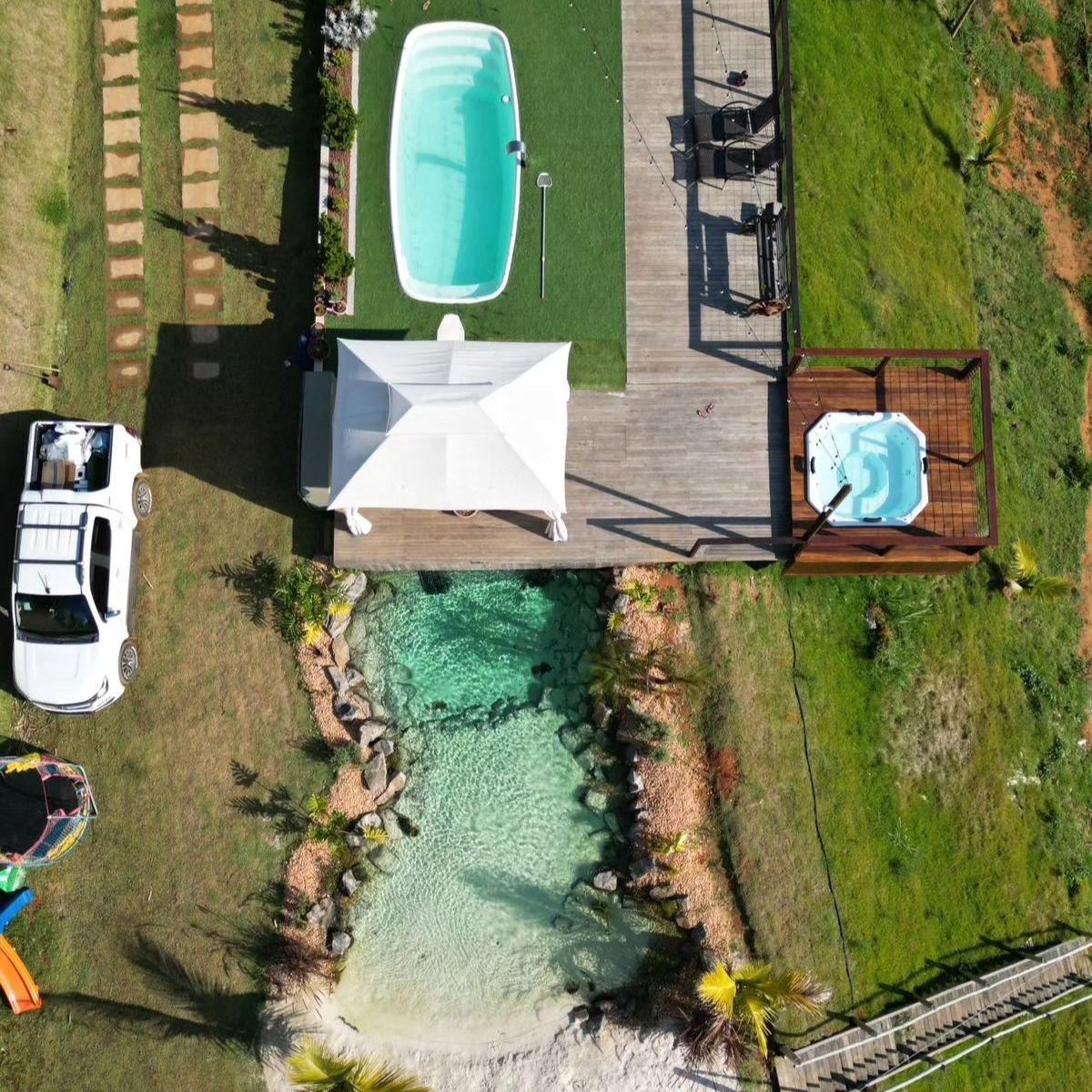Vue drone d´une piscine biologique de style plage, une piscine standard et un spa privé, par Life Ecossistemas, pour Casa Grand Valley