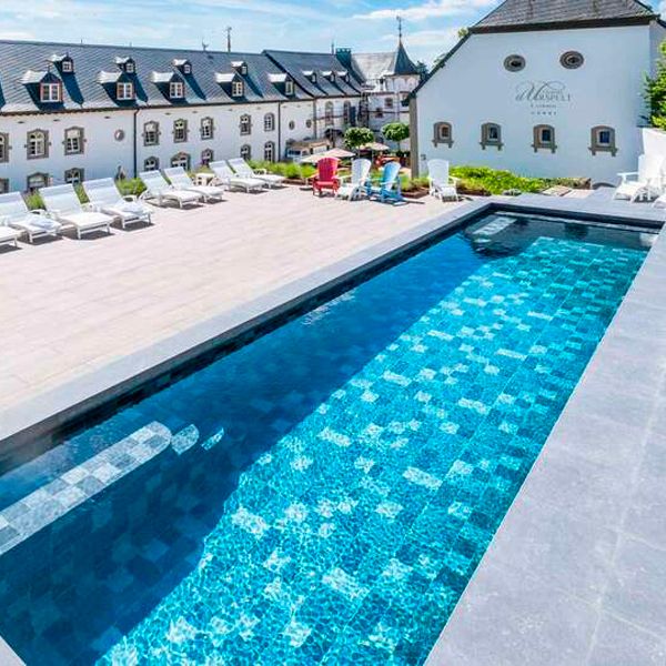piscine extérieure d´un hôtel avec un revêtement en grès cérame, par Piscines Ondine