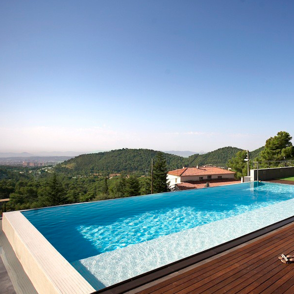 piscine infinity entourée d'une terrasse