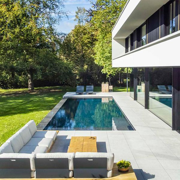 piscine à débordement, salon extérieur et jardin d'un projet par DC Pools, dans une maison au design moderne
