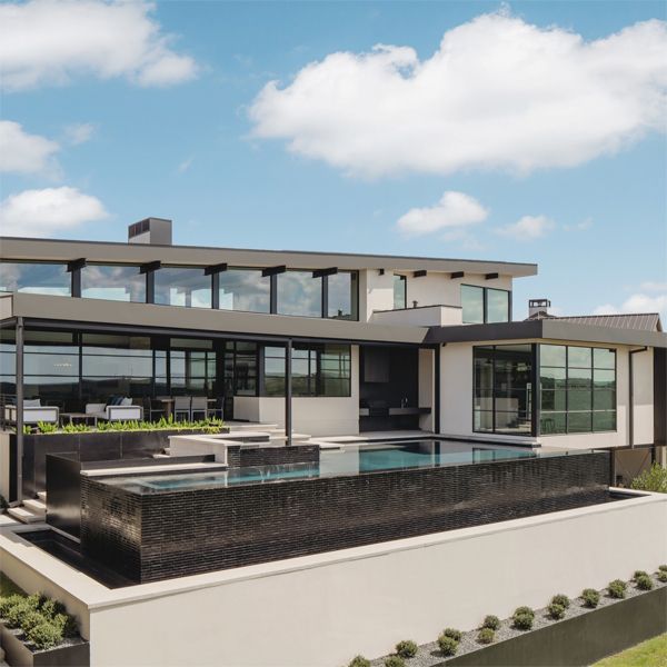 Piscine à débordement et spa, par Aqua Builders, dans une maison de style industriel moderne