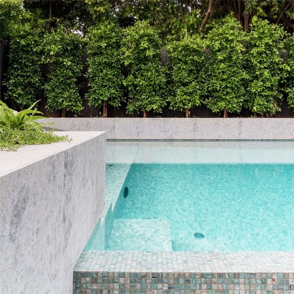 Détail de piscine à débordement de Feature Pools, avec une merveilleuse combinaison de matériaux tels que les carreaux de verre, la pierre...