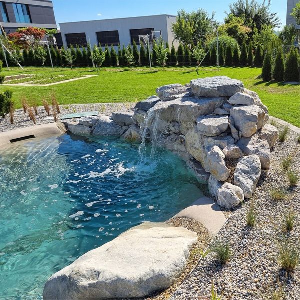 cascade sur les rochers d´une piscine style plage sur mesure, par Biodesign Pools Deutschland