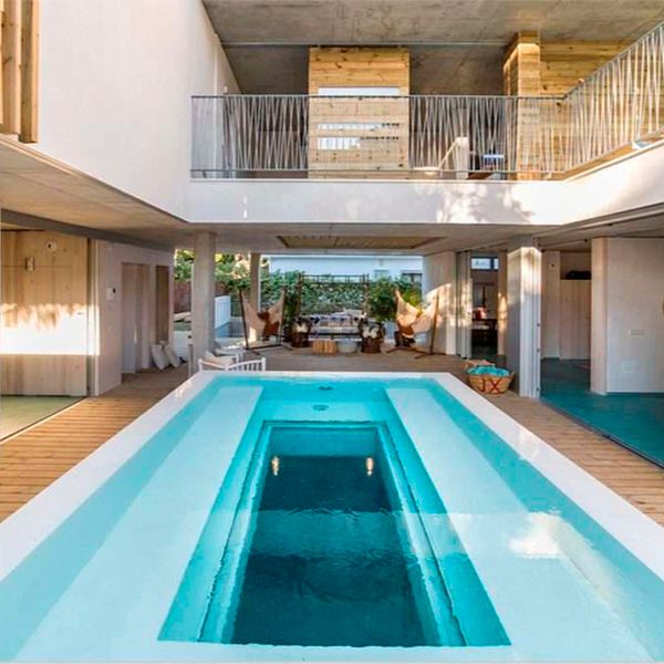 Piscine à débordement blanche avec fenêtre transparente au fond, par Espai Piscines