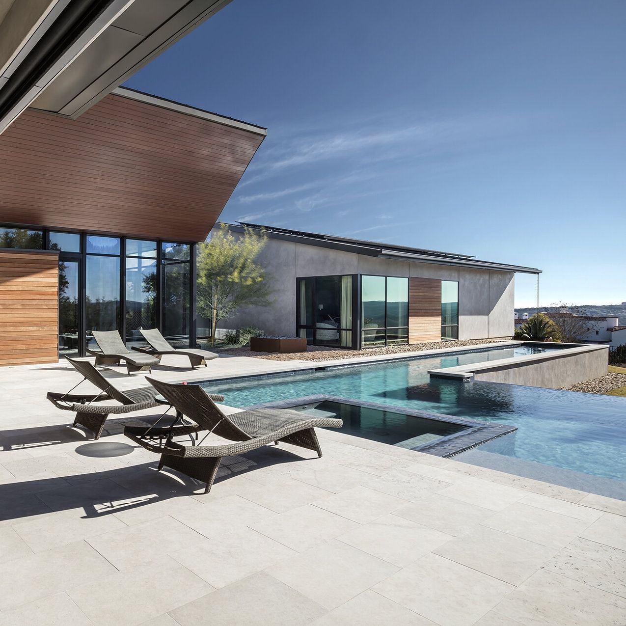 Piscine à débordement en L et spa intégré, dans un projet de MF Architecture