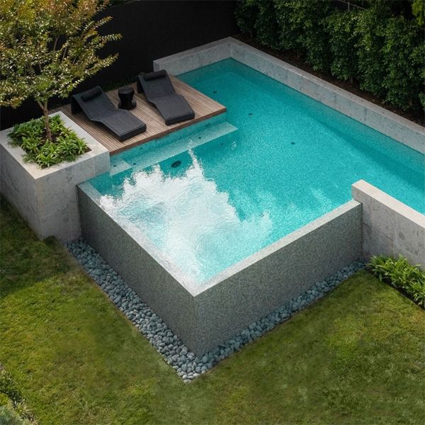Vue drone d'une piscine à débordement au design personnalisé raffiné, par Feature Pools, dans un jardin design moderne, avec une petite terrasse en bois et une belle combinaison de matériaux