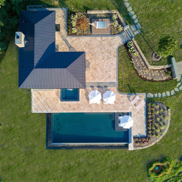 Vue drone d'une maison au design classique avec piscine à débordement et spa séparé, dans un projet de Colao & Peter