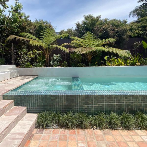 Petite piscine hors sol avec espace spa intégré, recouverte de carrelage vert, dans un complet projet d´aménagement paysager par Falling Waters Landscape