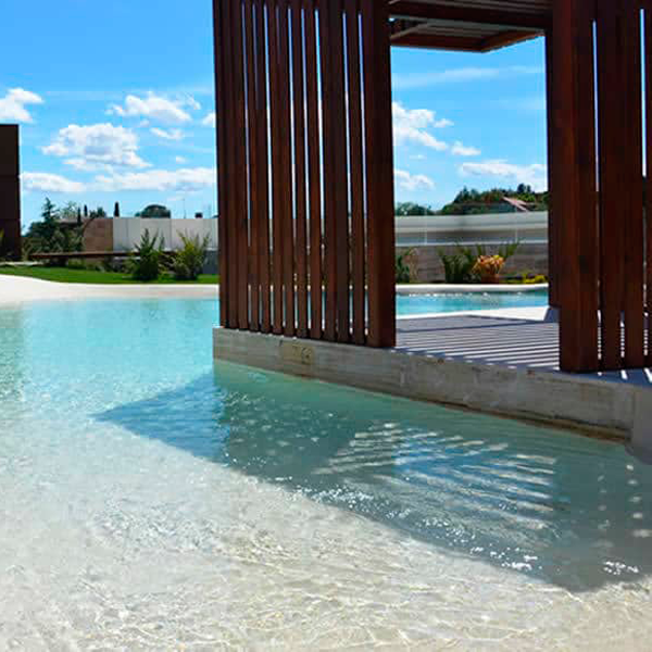 Piscine de sable, style plage, réalisée en Espagne, par Piscinas de Arena, et projet d'aménagement paysager complet
