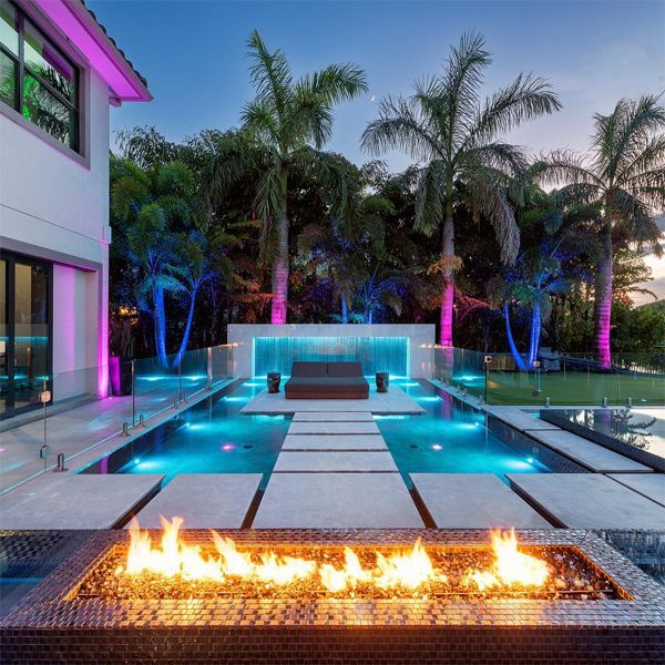 espace aquatique de luxe dans une maison privée, avec piscine à débordement, spa, jeux d'eau, foyer... par Ikes Carter Pools, au coucher du soleil