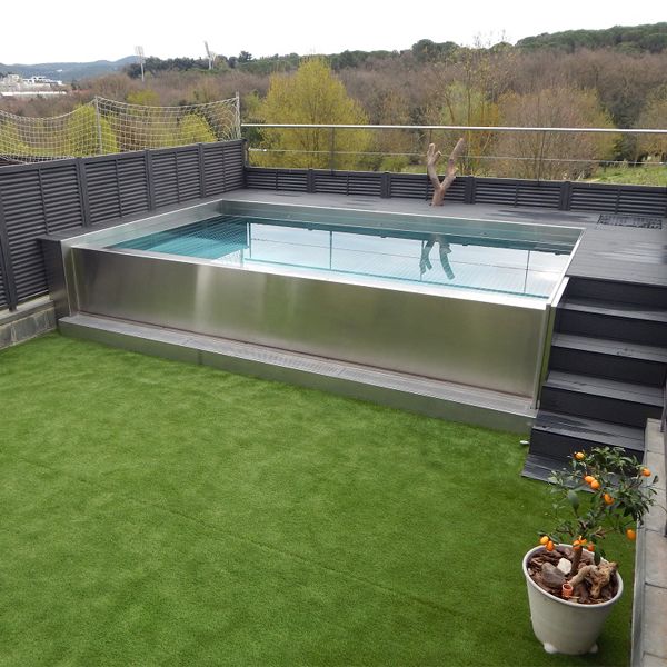 piscine à débordement en acier inox, dans une petit jardin privé, par Inox Personal Designs