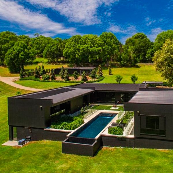 vue drone piscine à débordement couloir de nage dans une maison moderne, par Liquid Pool Design