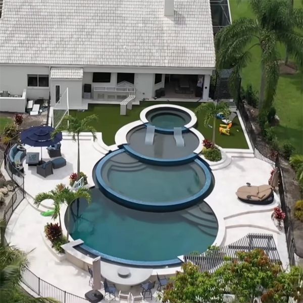 Vue drone d'une piscine à débordement à 4 niveaux, en forme d'anneaux superposés, par Lucas Lagoons